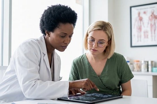 A doctor talking with a patient during an evaluation.