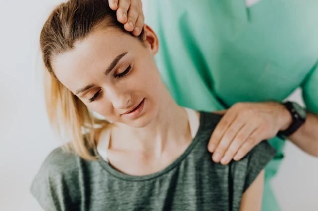 Physical therapist guiding a patient through a recovery exercise.