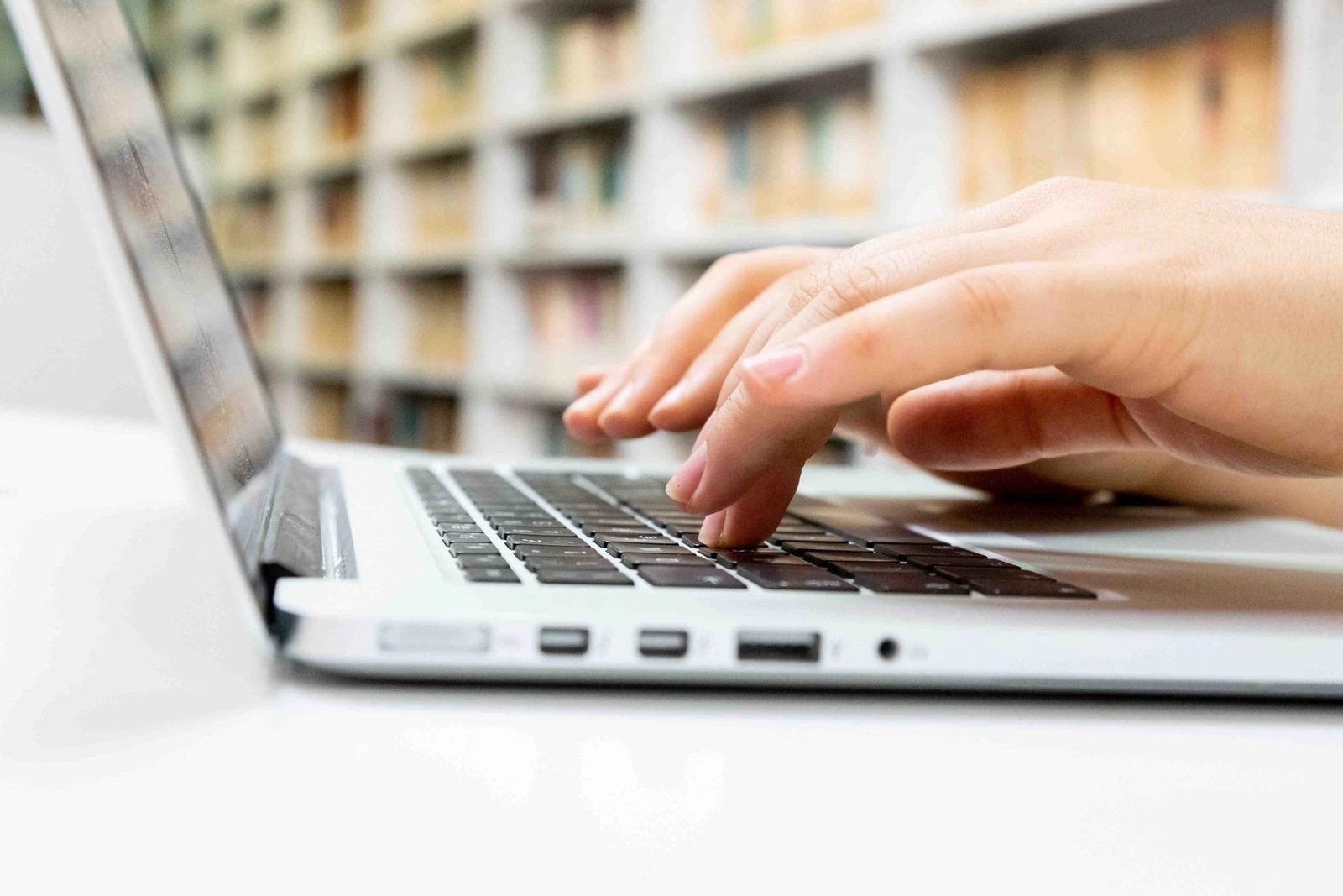 Hands typing on a laptop in front of shelves of files, the kind of record-keeping that goes into an injury claim.