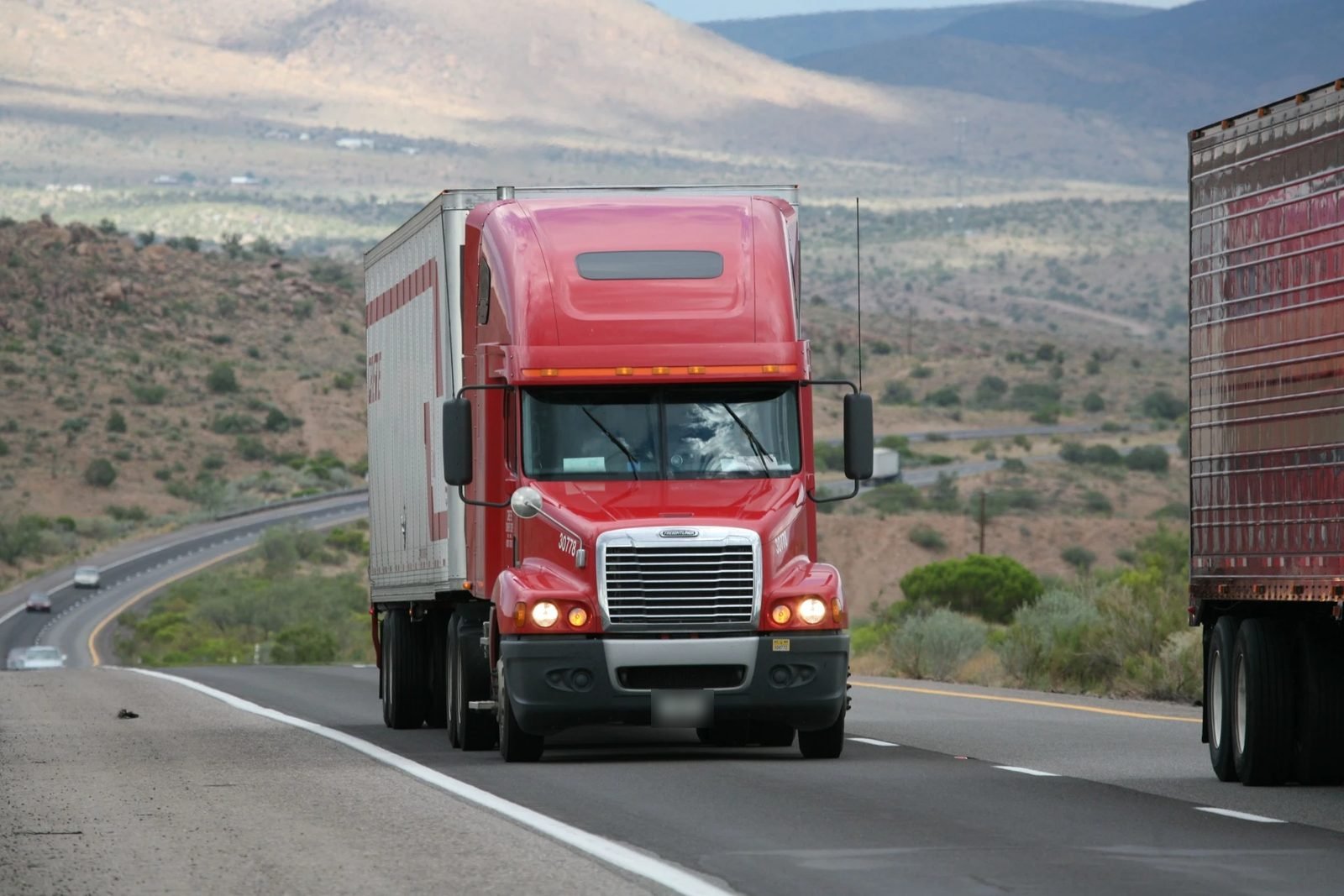 A tractor-trailer traveling down a highway.
